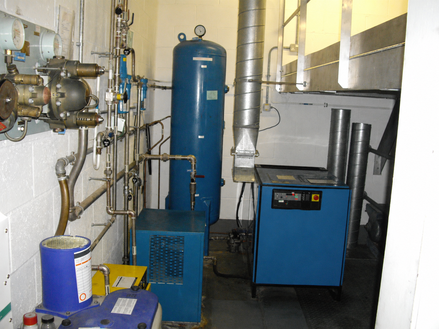 Industrial low-pressure compressor installation with receiver vessel and pipework